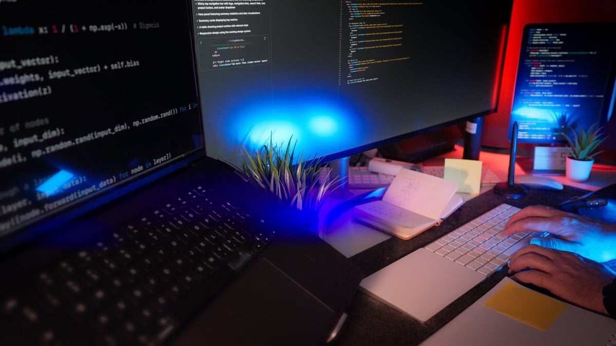 Developer working on website design in modern workspace with RGB lighting